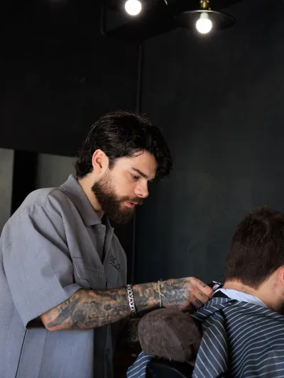 Barbeiro Iarle focado no corte de cabelo