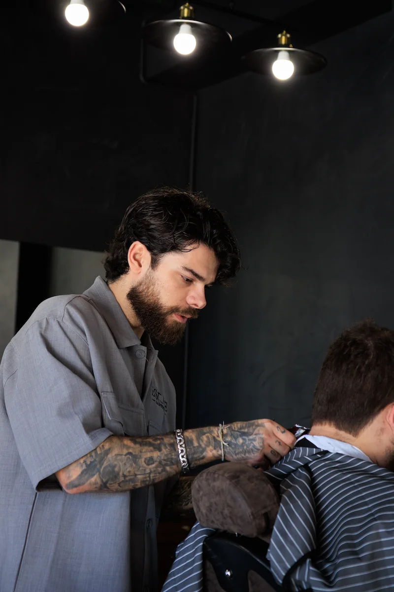 Barbeiro Iarle focado no corte de cabelo